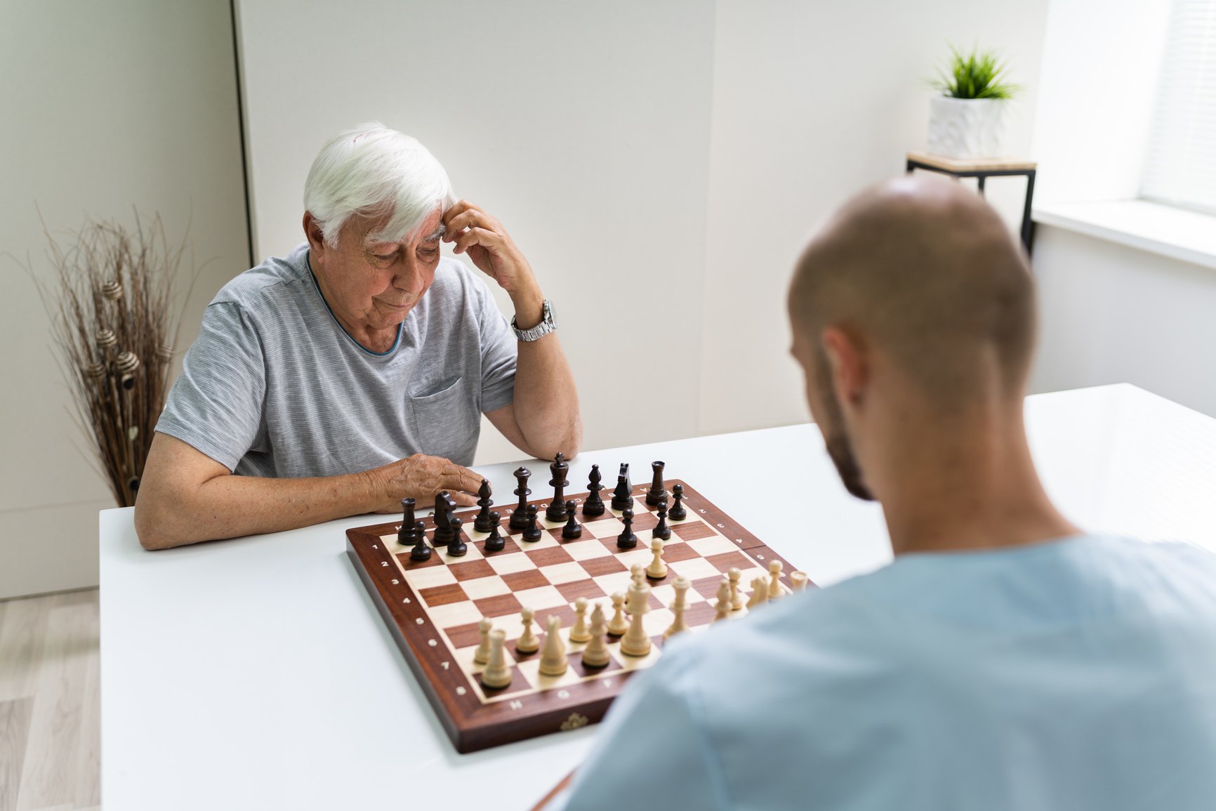 Elderly Senior Playing Chess With Caregiver